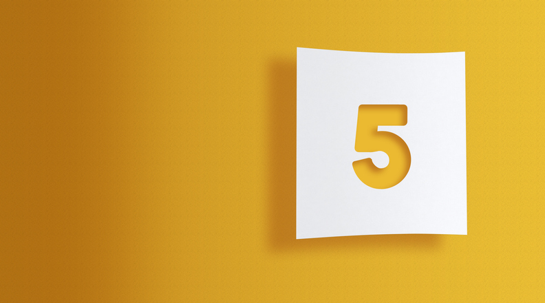 Number 5 cut out on white square paper on yellow background with large copy space